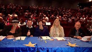 jury van Circus got Talent zit in op de eerste rij van een volle zaal in het theater, Arlette is juryvoorzitter en zit in het midden